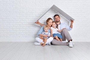 Family of four under cardboard roof white setting
